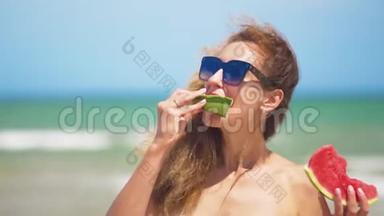 微笑的女人在海滩上<strong>吃西瓜</strong>。 女人<strong>吃</strong>美味的夏天水果。 暑假快乐。